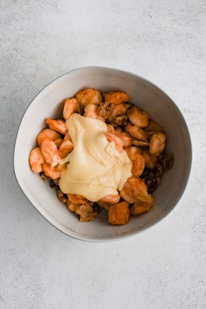 White bowl filled with fried shrimp, candied walnuts, and homemade mayonnaise sauce.