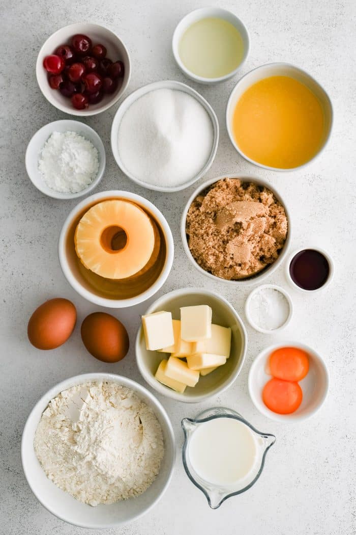 All of the ingredients needed to make a classic pineapple upside down cake in individual measuring cups and ramekins.