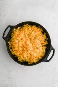 Large cast iron skillet filled with oven baked potato chip chicken.