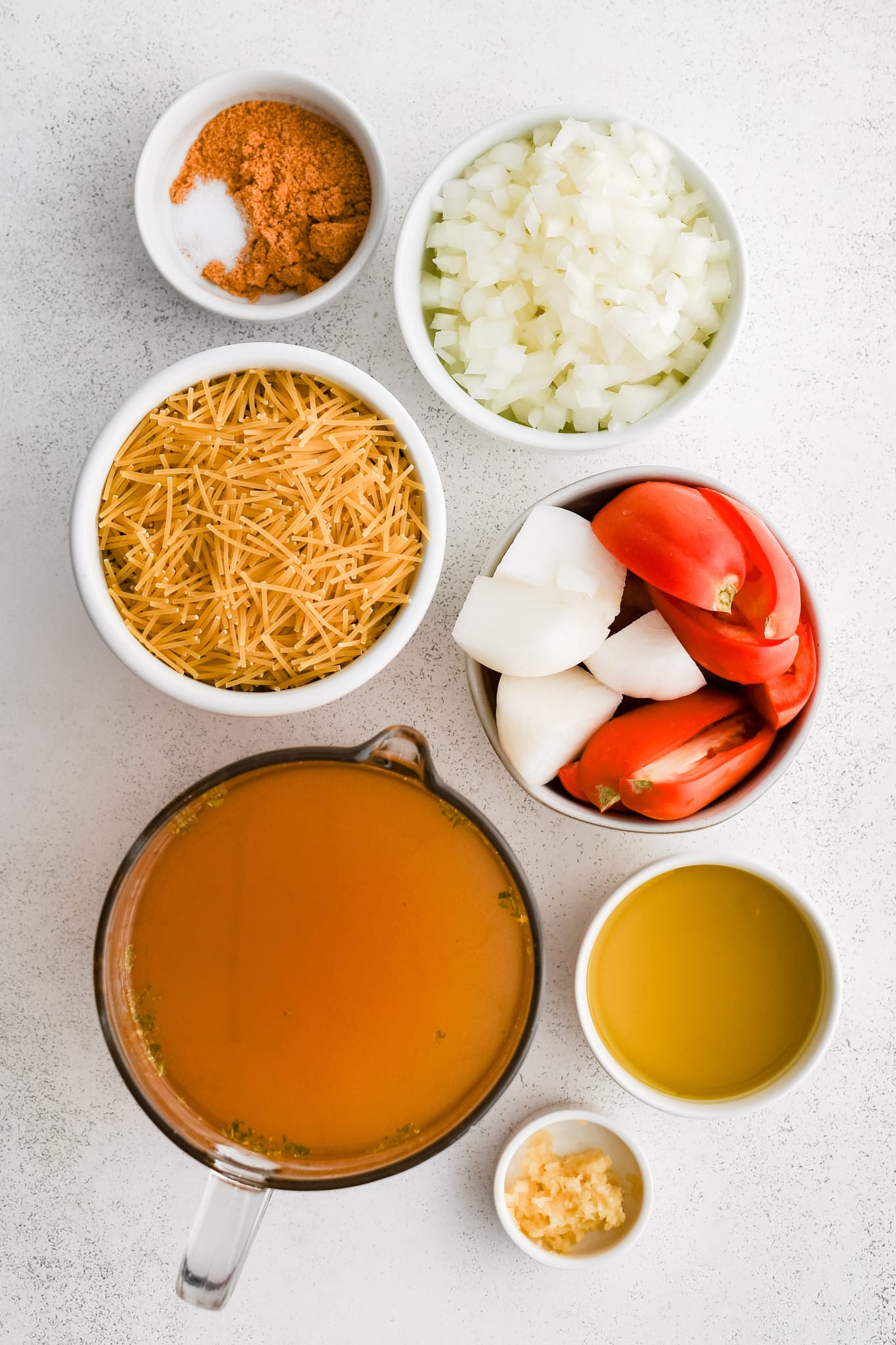 All of the ingredients needed to make homemade Sopa De Fideo in individual measuring cups and ramekins.
