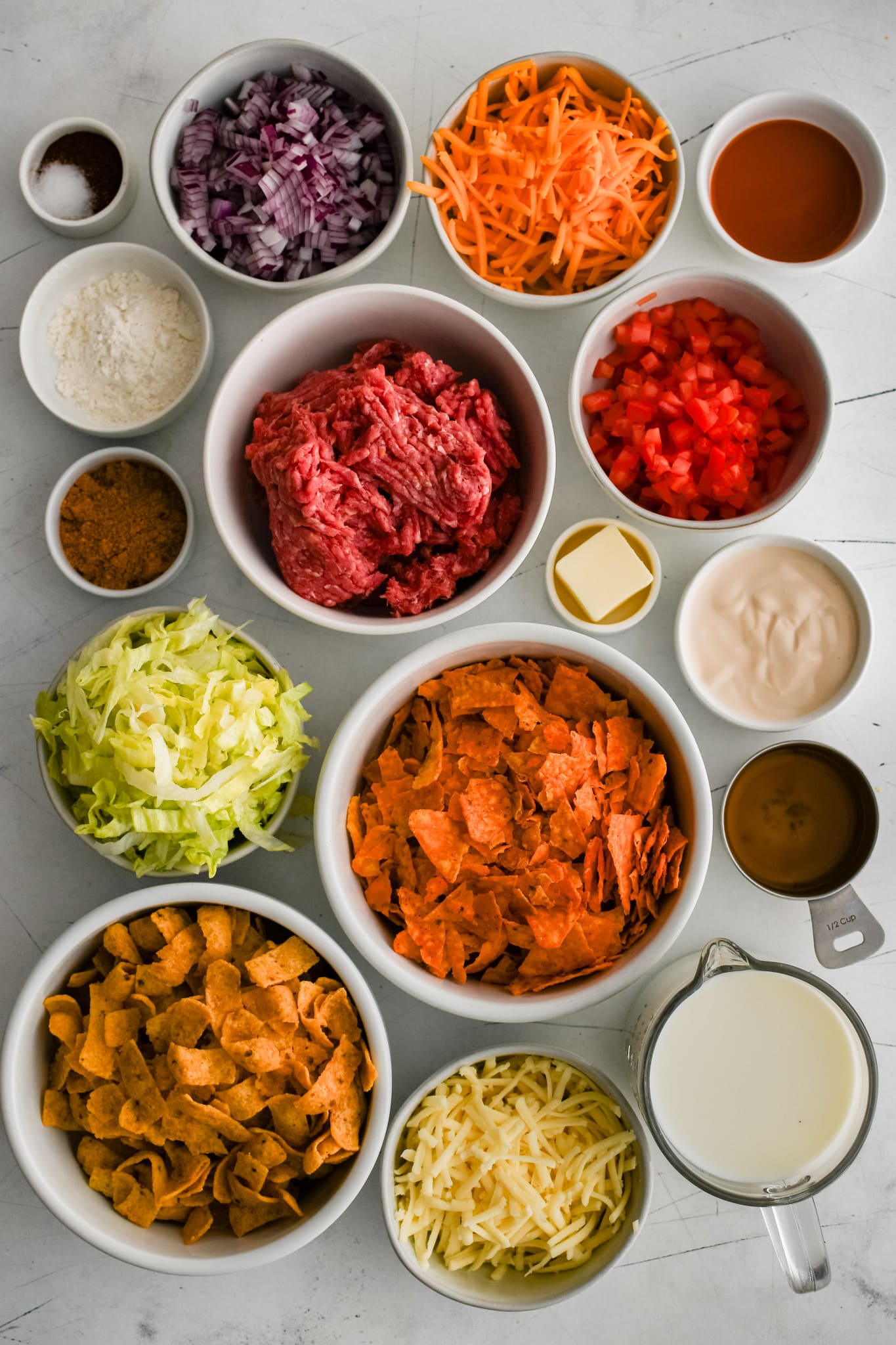 All of the ingredients needed to make walking taco casserole recipe in individual measuring cups and ramekins.