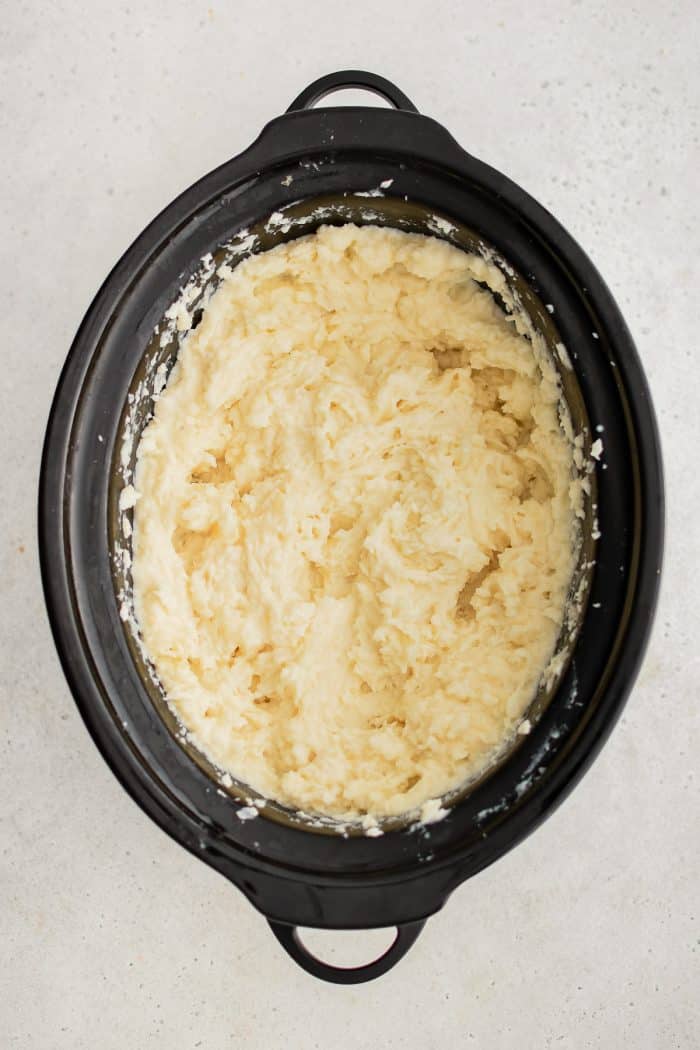 Large crock pot filled with mashed potatoes.