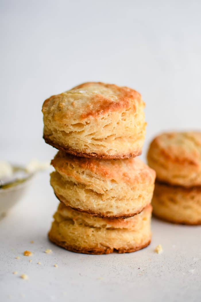 Three golden buttermilk biscuits stacked on top of one another.