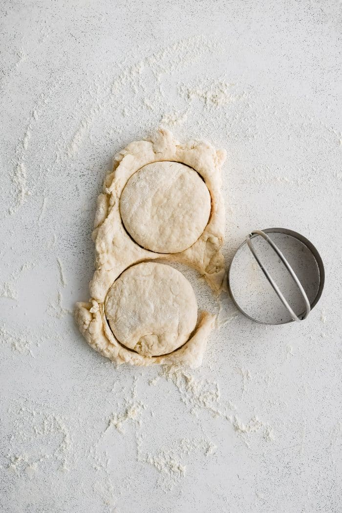 Two biscuits cut from a small 1/2-inch thick rectangle of biscuit dough.