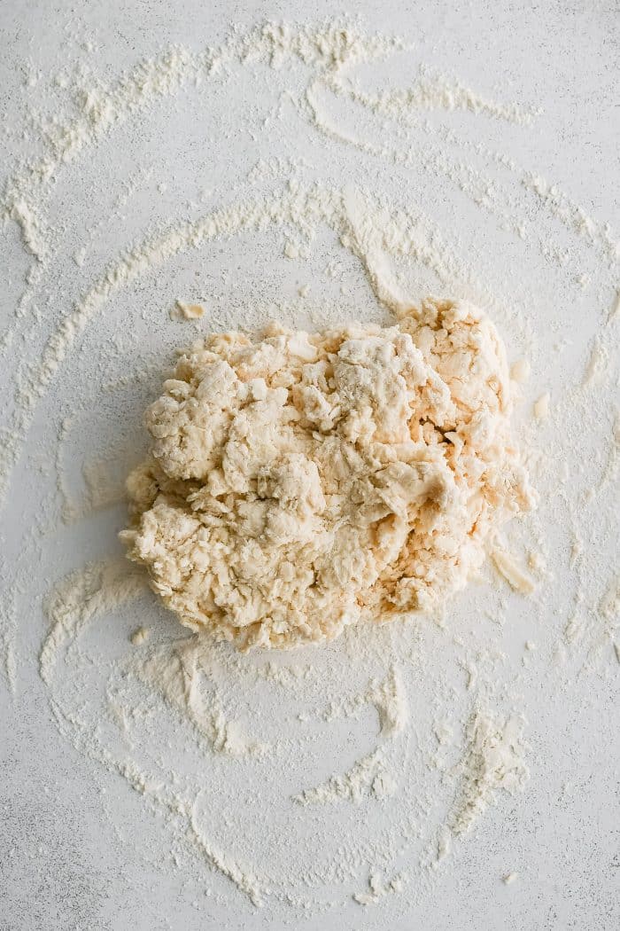 Homemade buttermilk biscuit dough turned out on a lightly floured work surface.