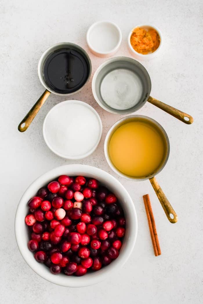 All of the ingredients needed to make homemade cranberry sauce in individual measuring cups and ramekins.