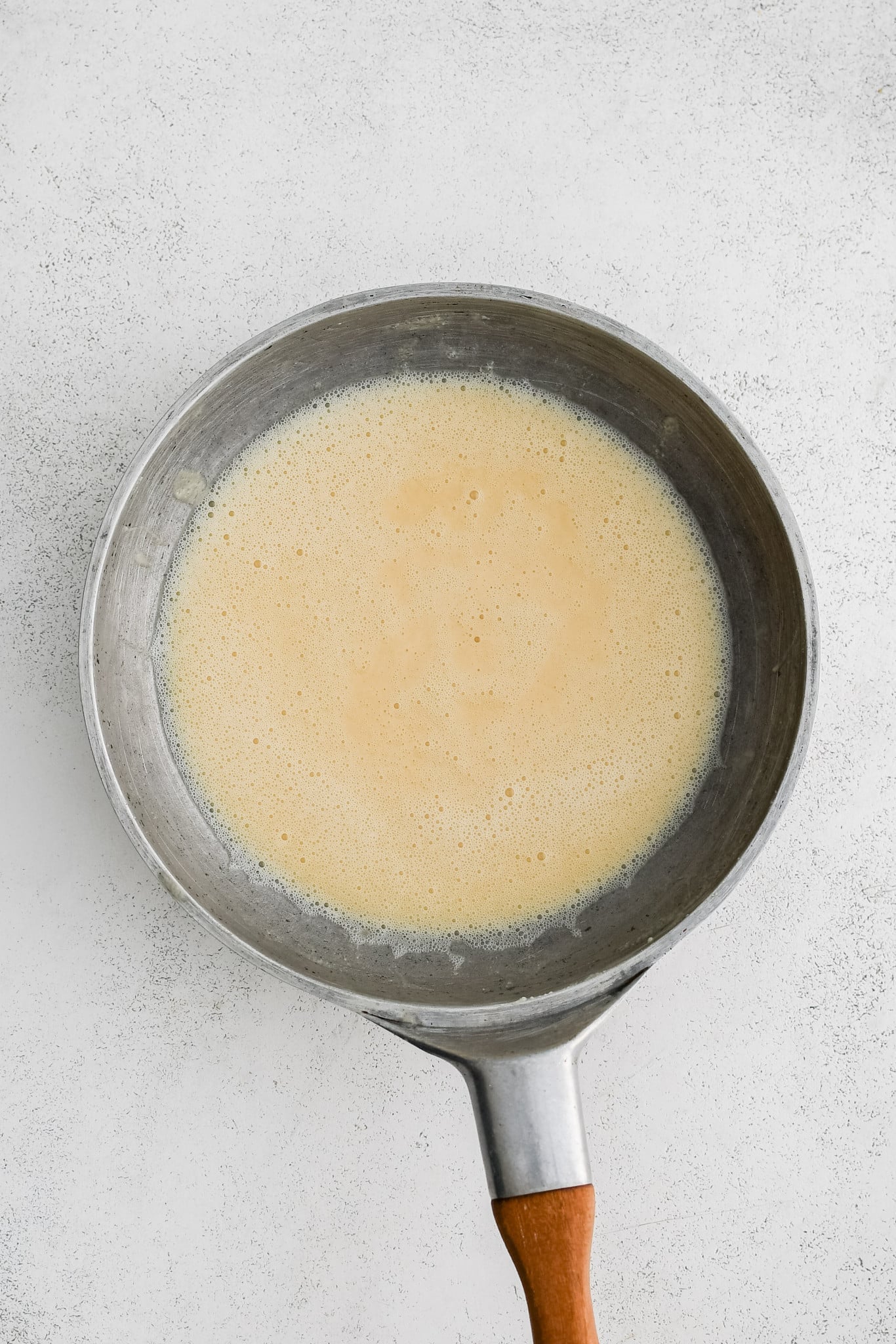 A white roux in a large stainless steel skillet.