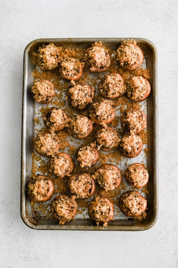 Large baking sheet filled with stuffed mushrooms topped with buttery breadcrumb topping.