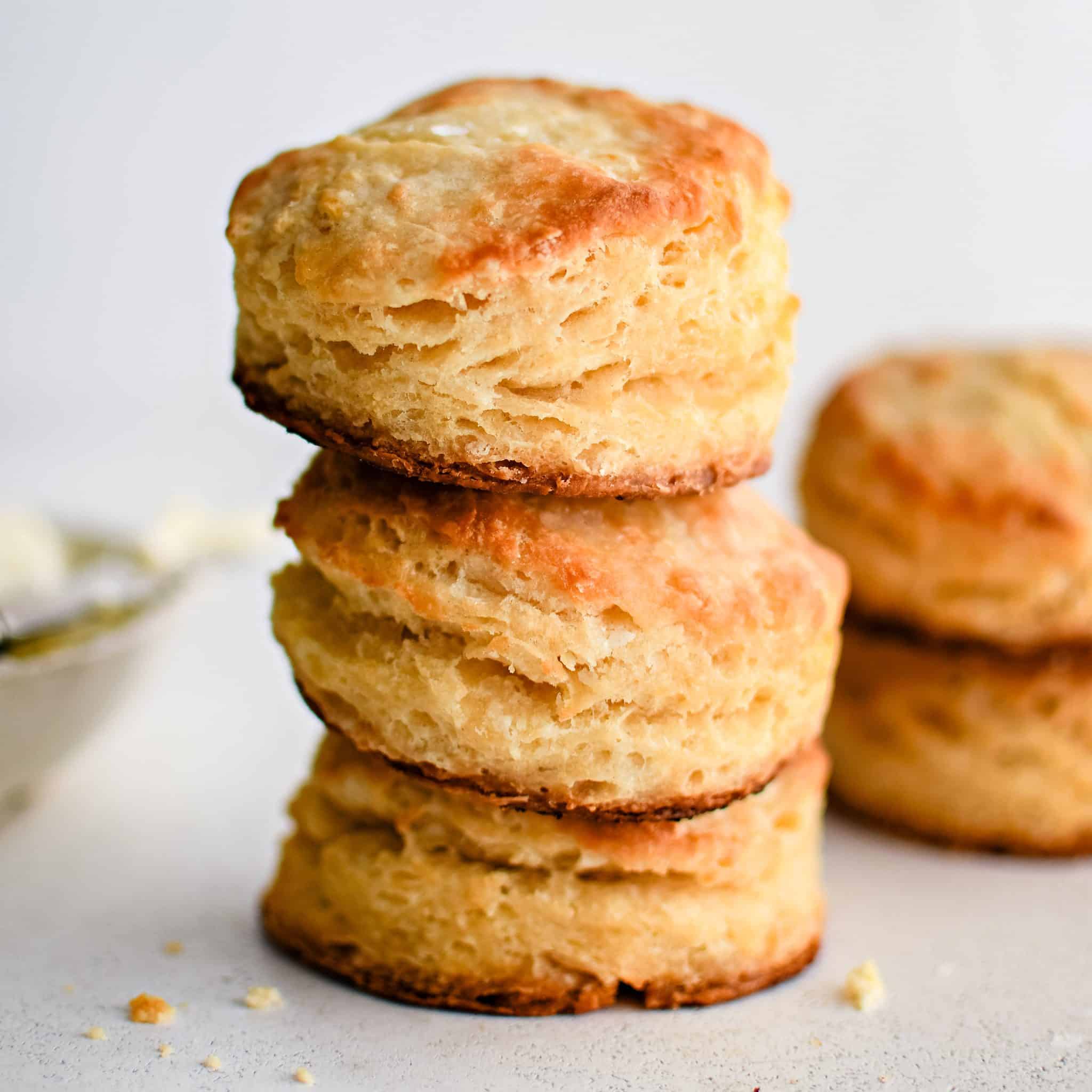 Three golden buttermilk biscuits stacked on top of one another.