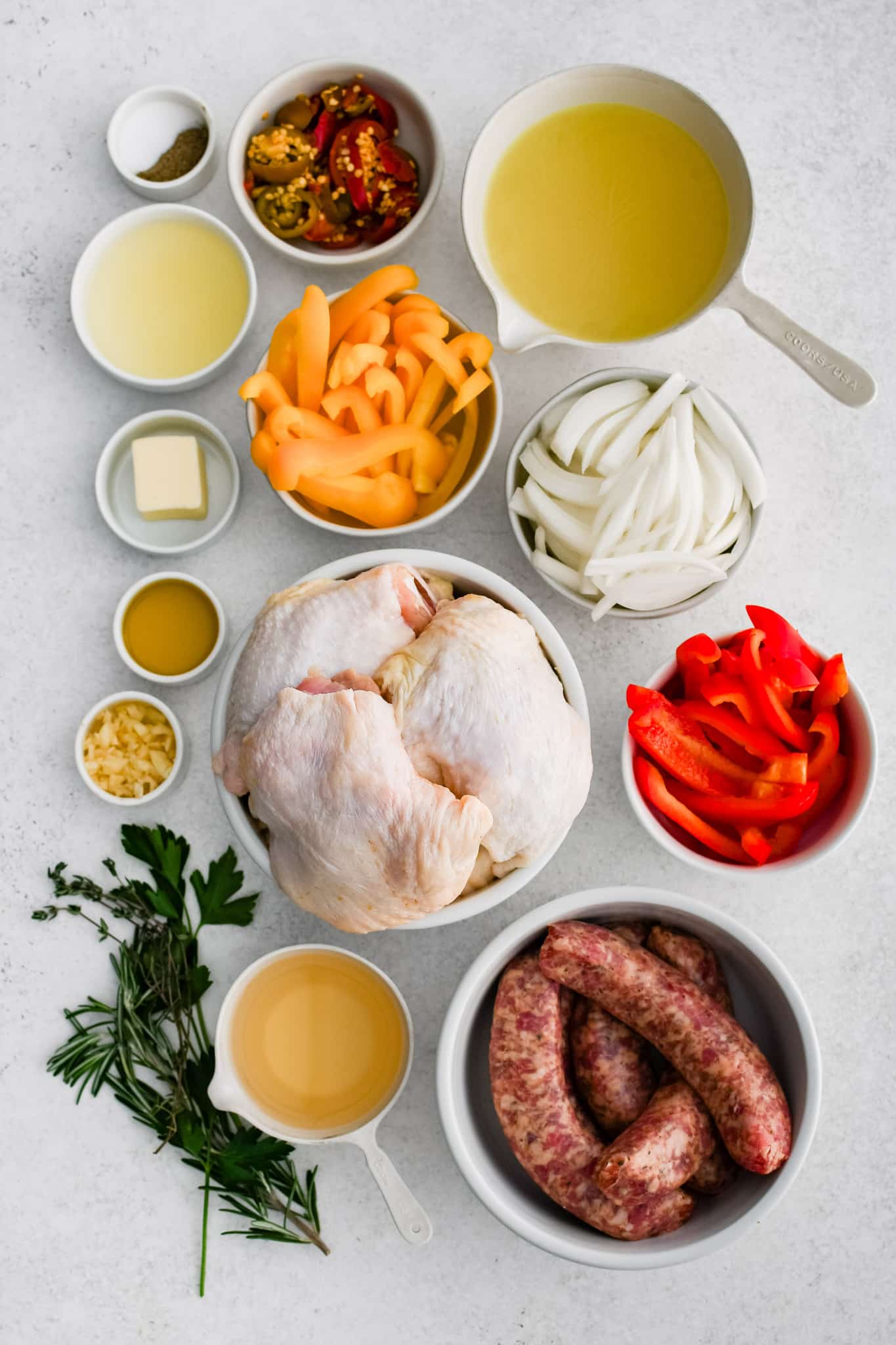 All of the ingredients needed to make Chicken Scarpariello in individual bowls, measuring cups, and ramekins.