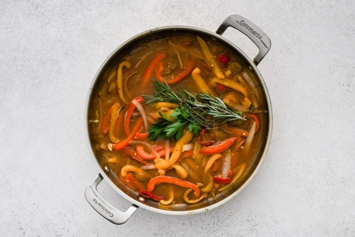 Softened bell peppers, onion, and garlic in a broth consisting of white wine, chicken broth, and cherry pepper juice, and topped with fresh sprigs of parsley, rosemary, and thyme.