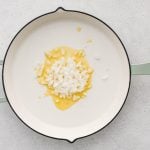 Large skillet with olive oil and diced white onion.