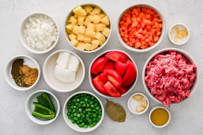 All of the ingredients needed to make Mexican Picadillo in individual measuring cups and ramekins.