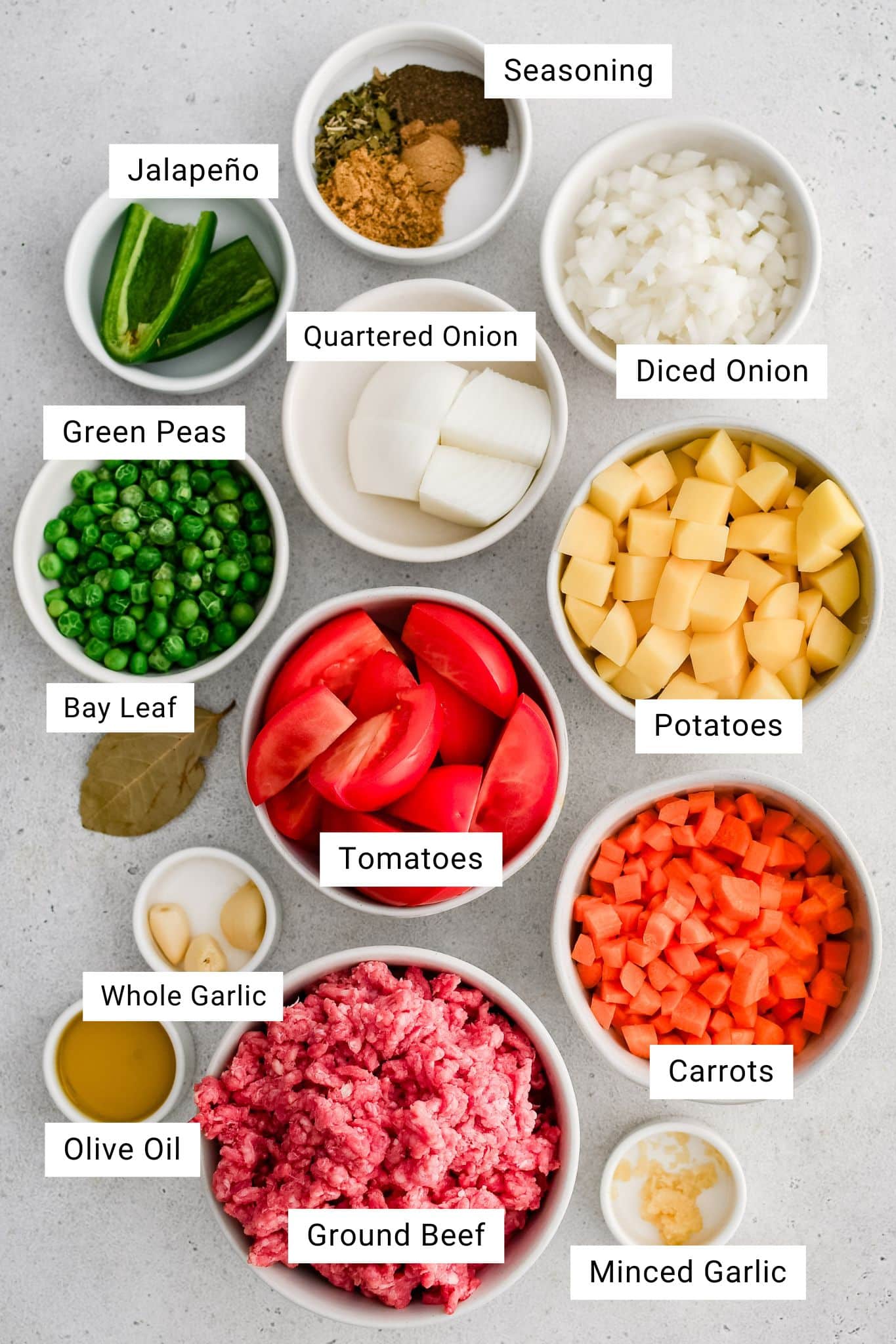 All of the ingredients needed to make Mexican Picadillo measured and in individual bowls.