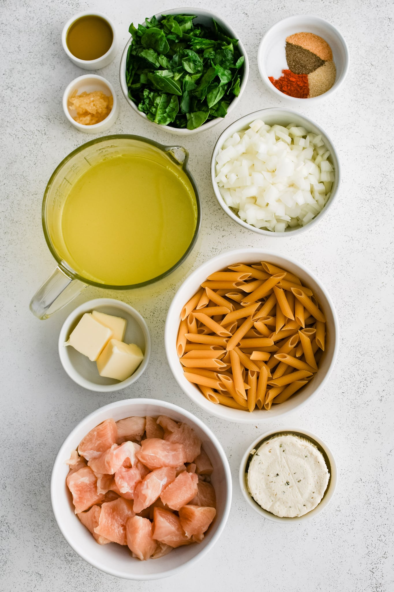 All of the ingredients needed to make Boursin cheese pasta in individual bowls, measuring cups, and ramekins.