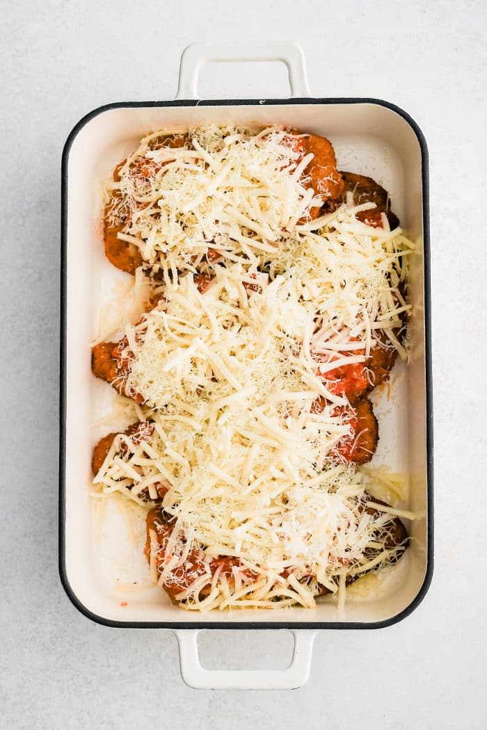 Large baking dish with breaded fried chicken cutlets topped with homemade tomato sauce and shredded cheese.