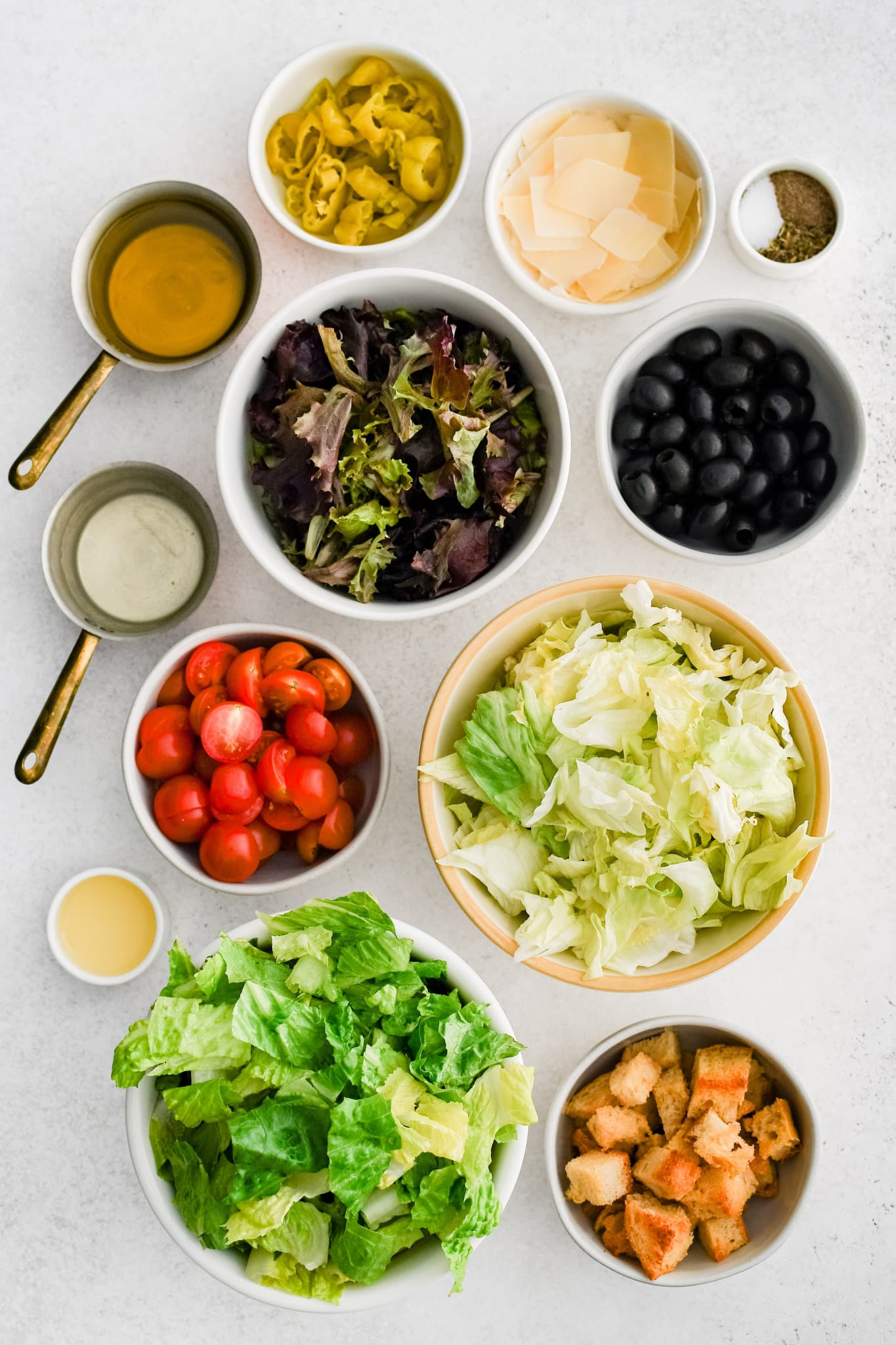Ingredients for Italian Salad measured out and set aside in individual serving bowls.