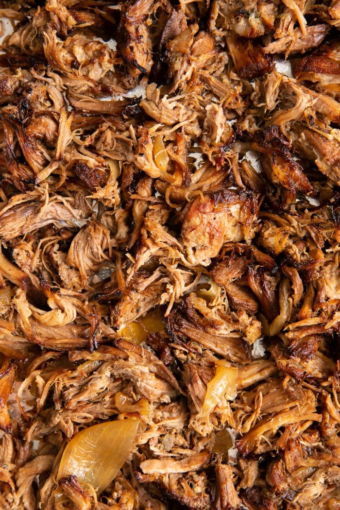 Shredded crispy pulled pork carnitas on a large baking sheet.