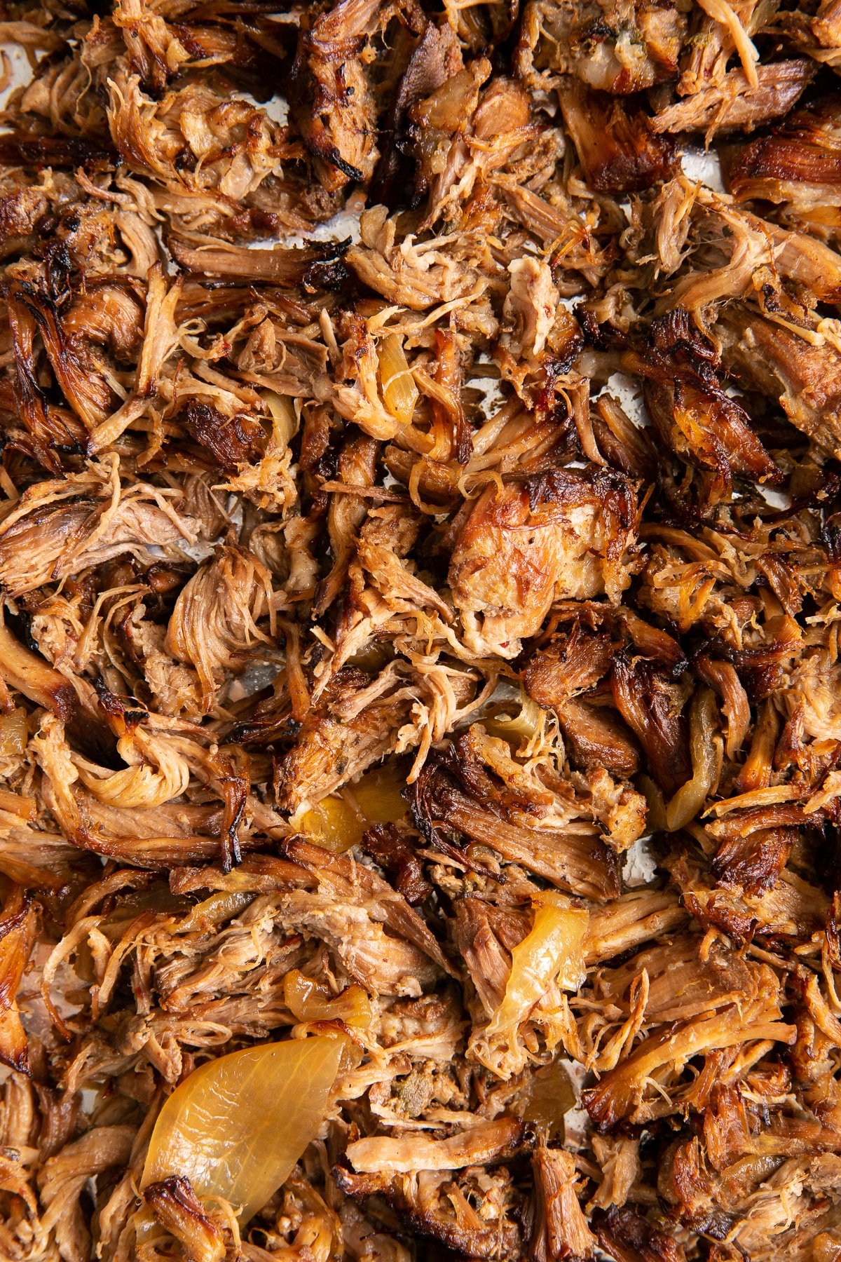Shredded crispy pulled pork carnitas on a large baking sheet.