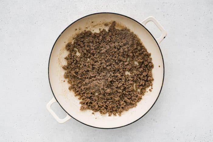 Ground beef browning in a skillet.