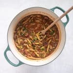 Uncooked penne pasta stirred into the simmering sauce along with green onions and parsley.