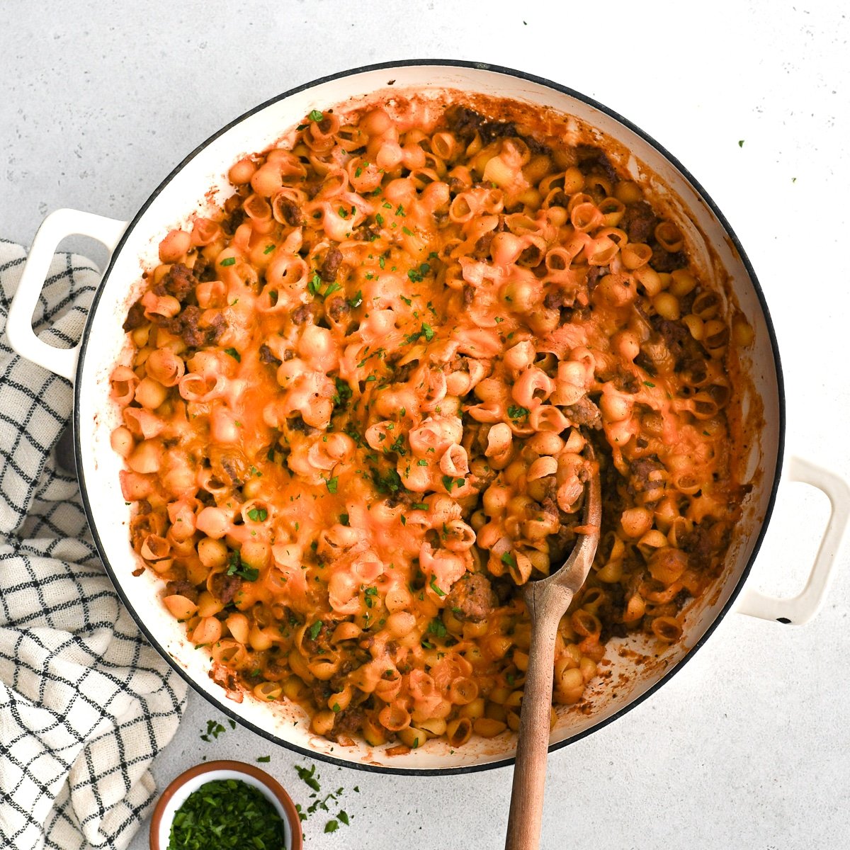 Baked sloppy joe casserole with pasta and topped with melted cheese in a large round casserole dish ready to be served.