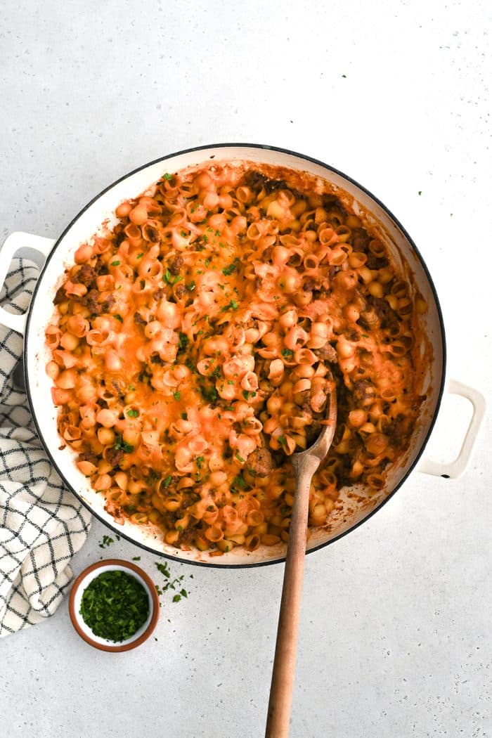 Baked sloppy joe casserole with pasta and topped with melted cheese in a large round casserole dish ready to be served.