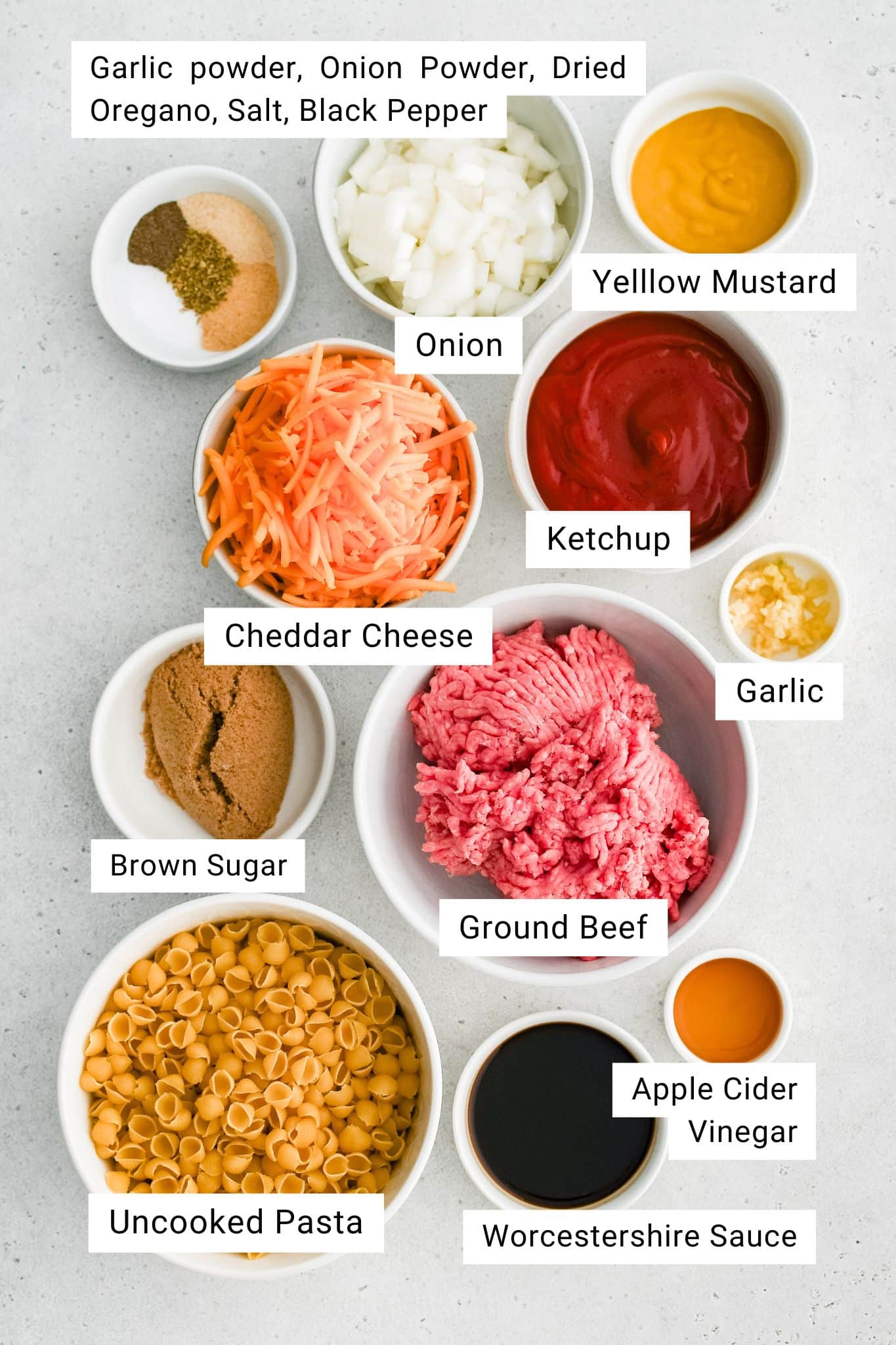 Ingredients for a Sloppy Joe Casserole Recipe are measured out and set aside in individual serving bowls.