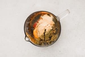 Ingredients for homemade sloppy joe sauce in a large glass measuring cup.