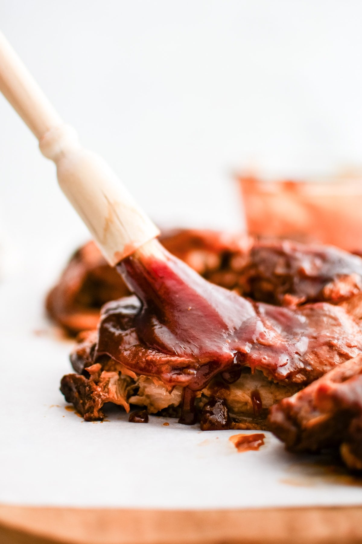 Basting a tender baby back rib with thick, sweet, tangy BBQ sauce.