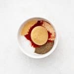 A small bowl with brown sugar, smoked paprika, garlic powder, onion powder, salt, and pepper.