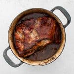 Braised pork shoulder just out of the oven, tender and caramelized.
