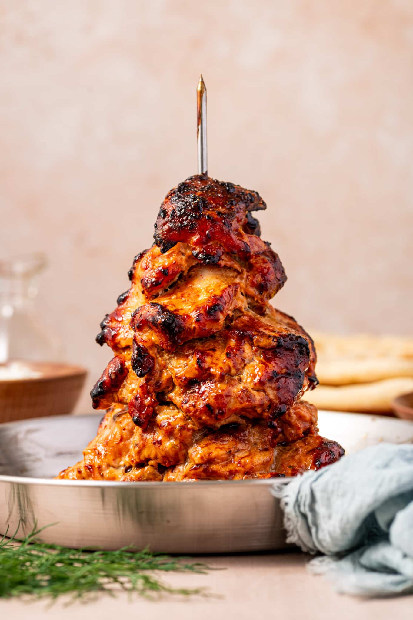 Tender slow-cooked chicken gyro on a vertical spit with crispy charred edges.