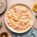 Marinated chicken thighs thoroughly coated in creamy yogurt marinade, placed in a bowl.