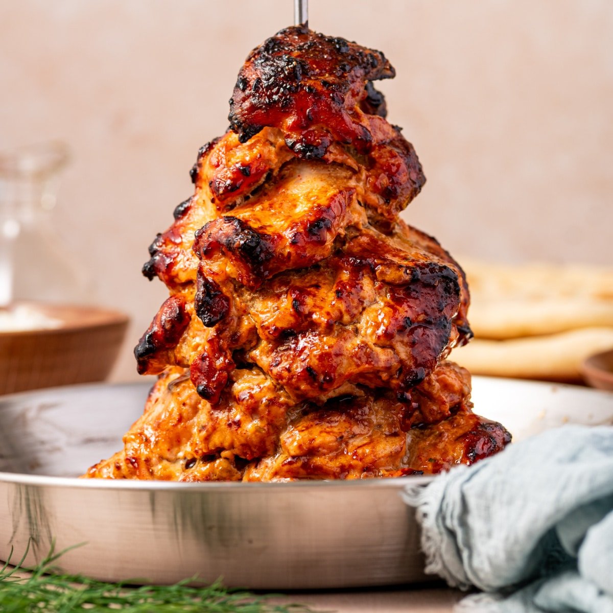 Tender slow-cooked chicken gyro on a vertical spit with crispy charred edges.