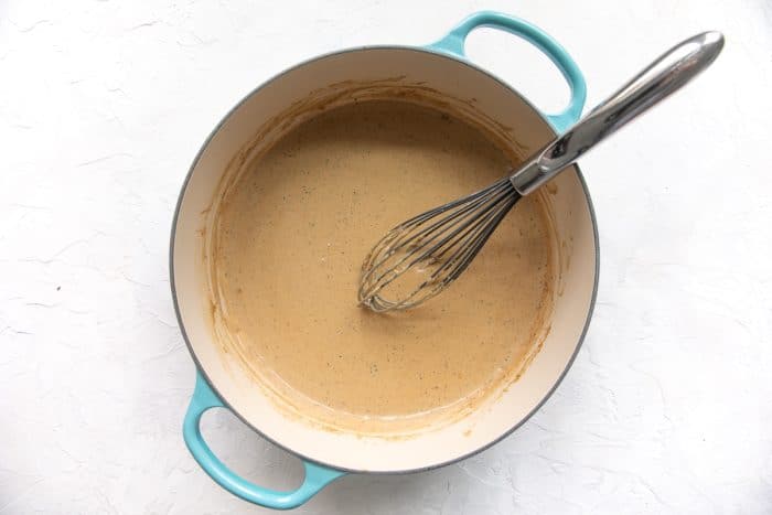 Creamy ranch sauce simmering in a skillet, thickened and ready for chicken.