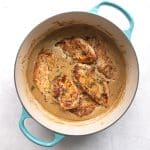 Golden pan-seared chicken cutlets in a turquoise-handled Dutch oven, simmering in creamy ranch gravy.