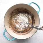 Garlic, flour, and ranch seasoning mix cooking in melted butter in a skillet to create a roux