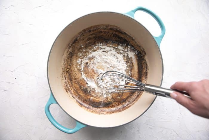 Garlic, flour, and ranch seasoning mix cooking in melted butter in a skillet to create a roux