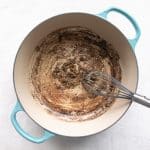 Thickened roux cooking in a Dutch oven.