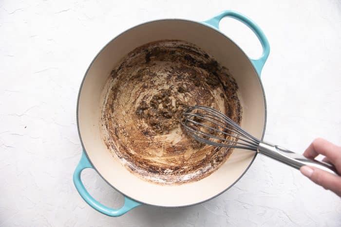 Thickened roux cooking in a Dutch oven.