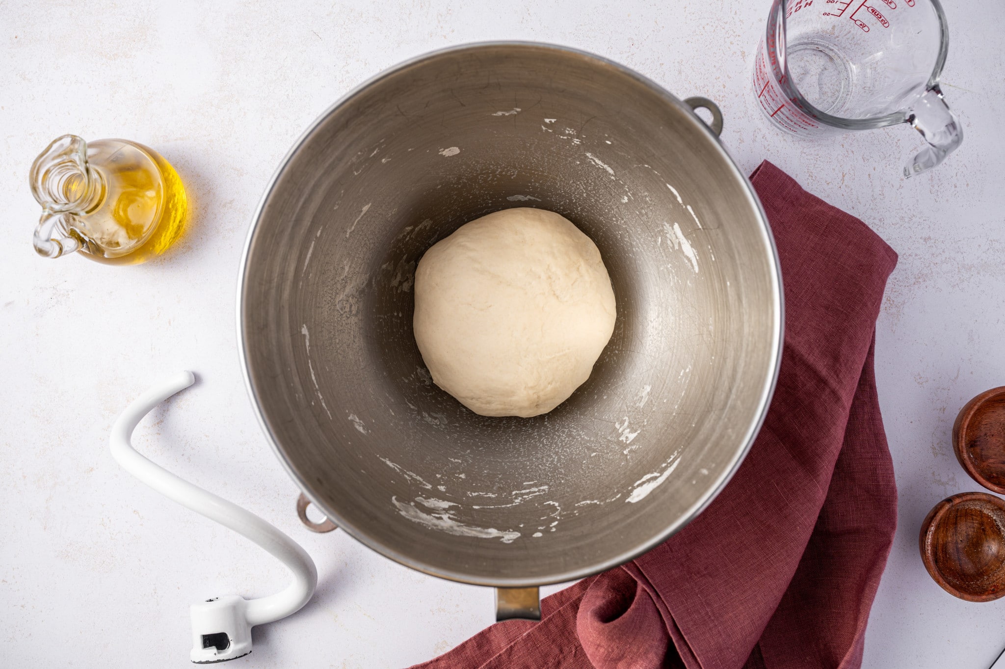 Dough in an oiled bowl, covered with a towel, ready to rise.
