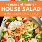 A big, round serving bowl brimming with a colorful house salad, perfectly layered with fresh lettuce, crisp cucumbers, juicy tomatoes, shredded carrots, Cheddar cheese, sliced hard-boiled eggs, and golden croutons, all finished with a generous drizzle of ranch dressing.