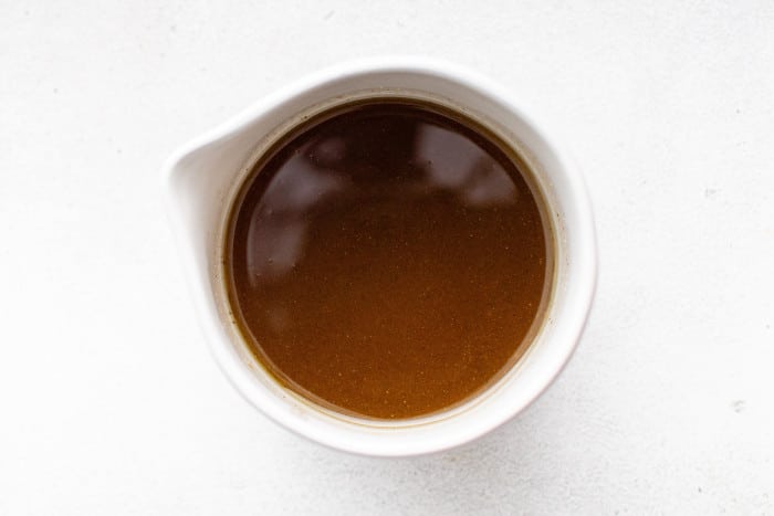 Whisked balsamic vinaigrette dressing in a white bowl