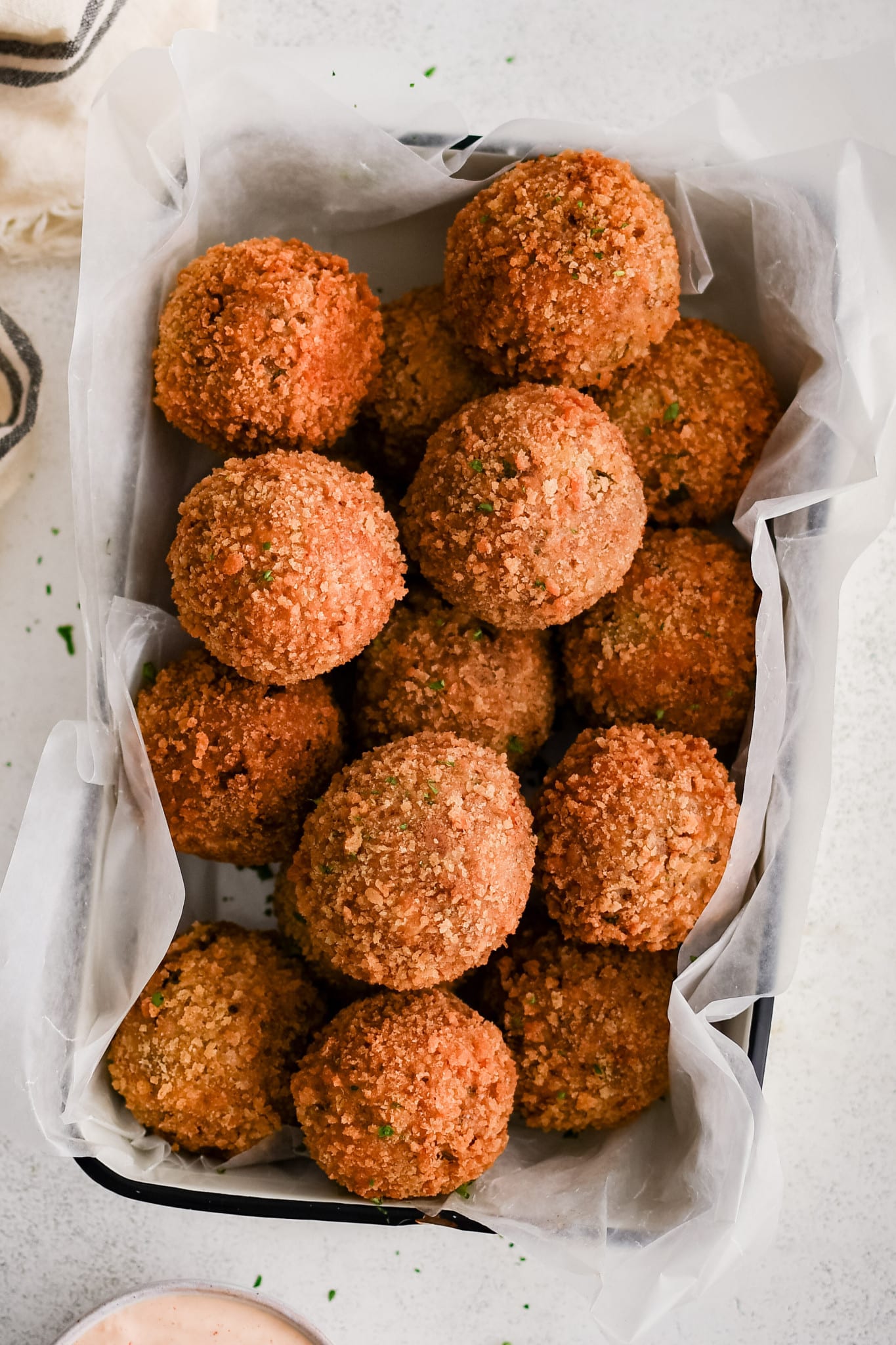 Crispy boudin balls in parchment-lined tray.