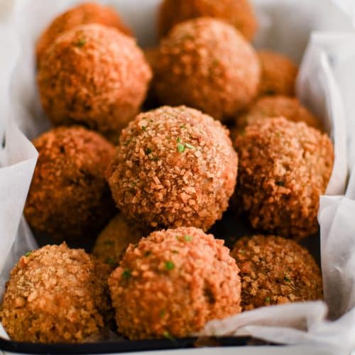 Close-up of crispy boudin balls in serving tray.