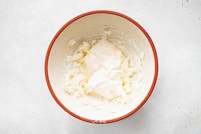 Cream cheese, mayo, and sour cream combined in a mixing bowl.