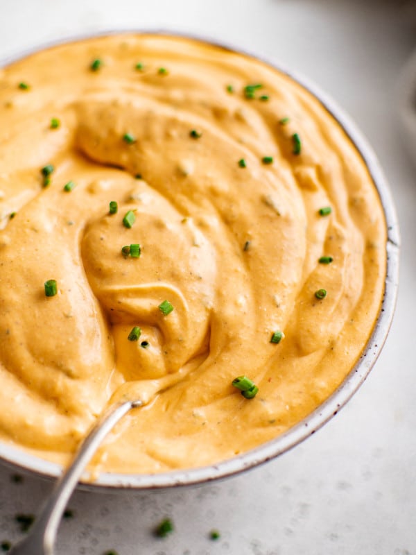 Close-up of spoon dipped into buffalo ranch sauce.