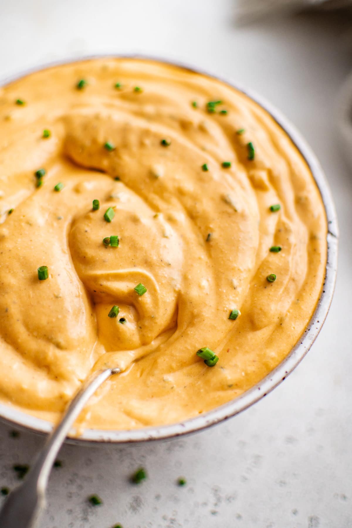 Close-up of spoon dipped into buffalo ranch sauce.