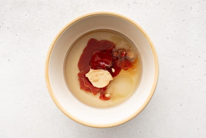 Bowl with unmixed ingredients for French dressing.